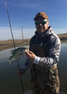 Easy Going. John Paczkowski of Bismarck, N.D. pauses with a nice white crappie caught on the fly rod during a break in the season’s gusty conditions. Simonson Photo.