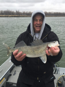 The author and his friend Kevin Thomas of Bismarck, pictured with a 21-inch walleye from the cold April outing, found themselves on a school of fish holding along a shift in the river bottom last week. Simonson Photo.