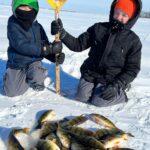 Piles of Smiles. The author’s sons Jackson(L) and AJ with a pile of perch from a recent ice outing, made easier and certainly more exciting with the help of the author’s regular fishing buddies. Simonson Photo.