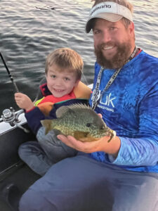 The author’s son and brother pose with a big sunfish caught at summer’s end. Simonson Photo